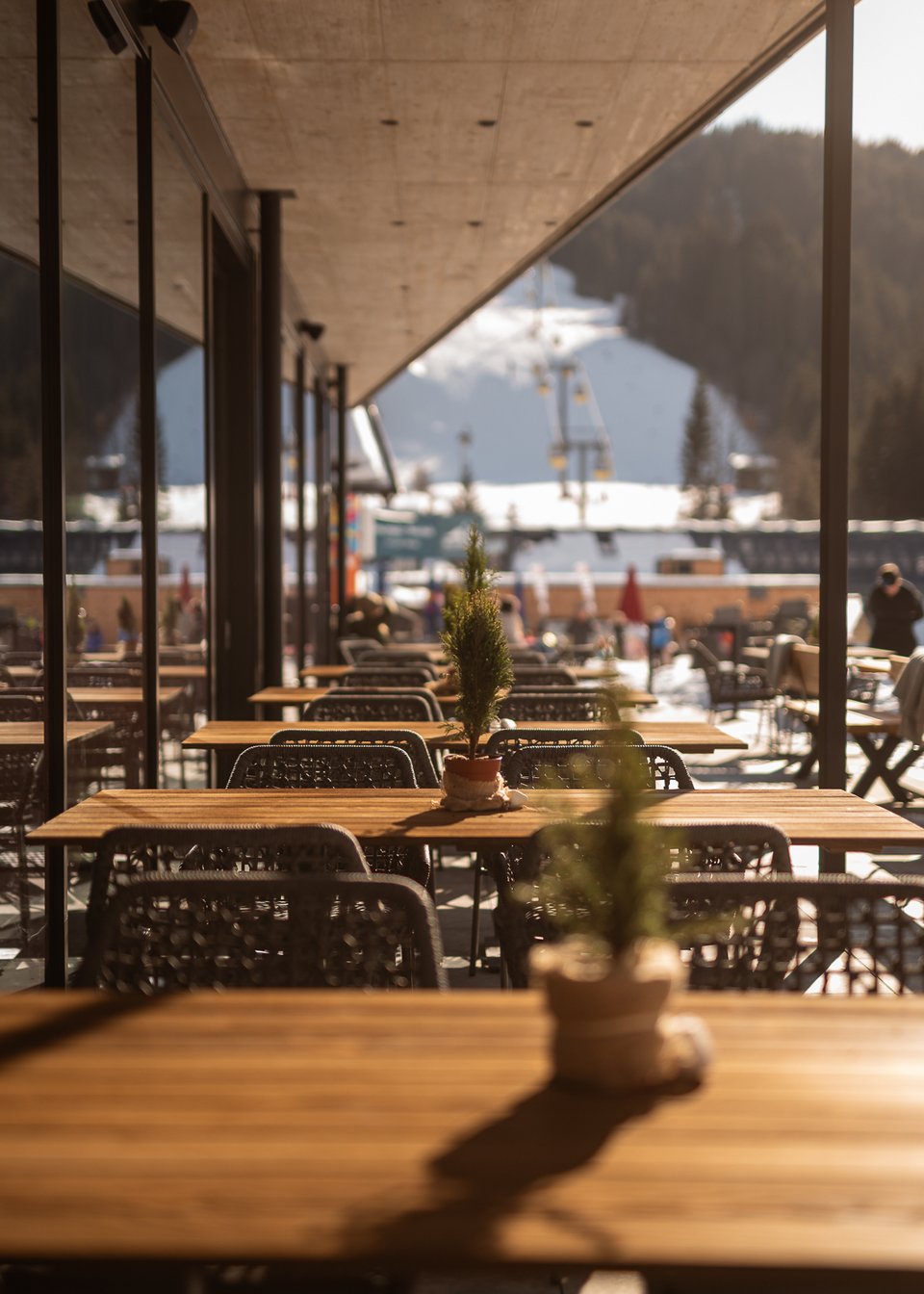 Hotel in Fieberbrunn: ADEA Lifestyle Suites Leere Außenterrasse eines Cafés mit Blick auf verschneite Berge