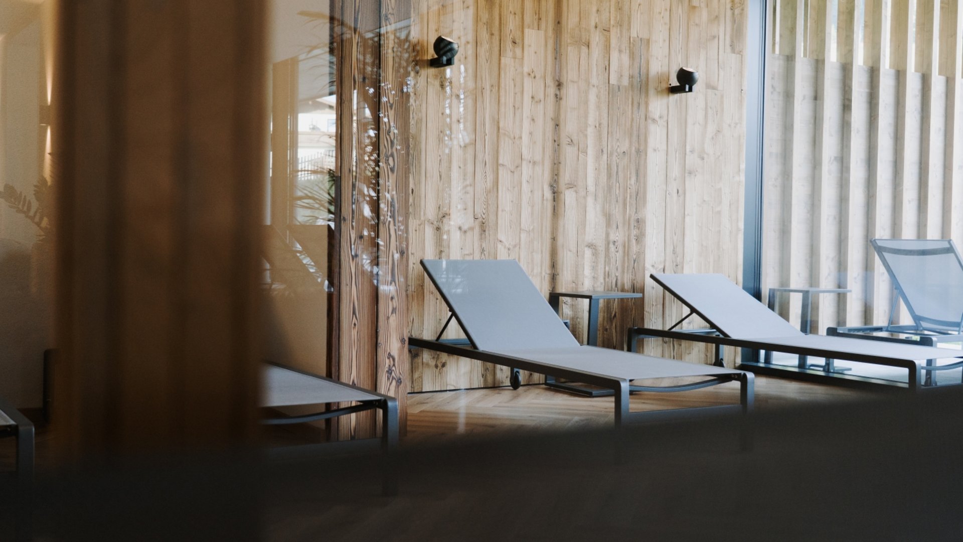 Day Spa inmitten der Kitzbüheler Alpen Leere Liegestühle in einem ruhigen Raum mit Holzvertäfelung