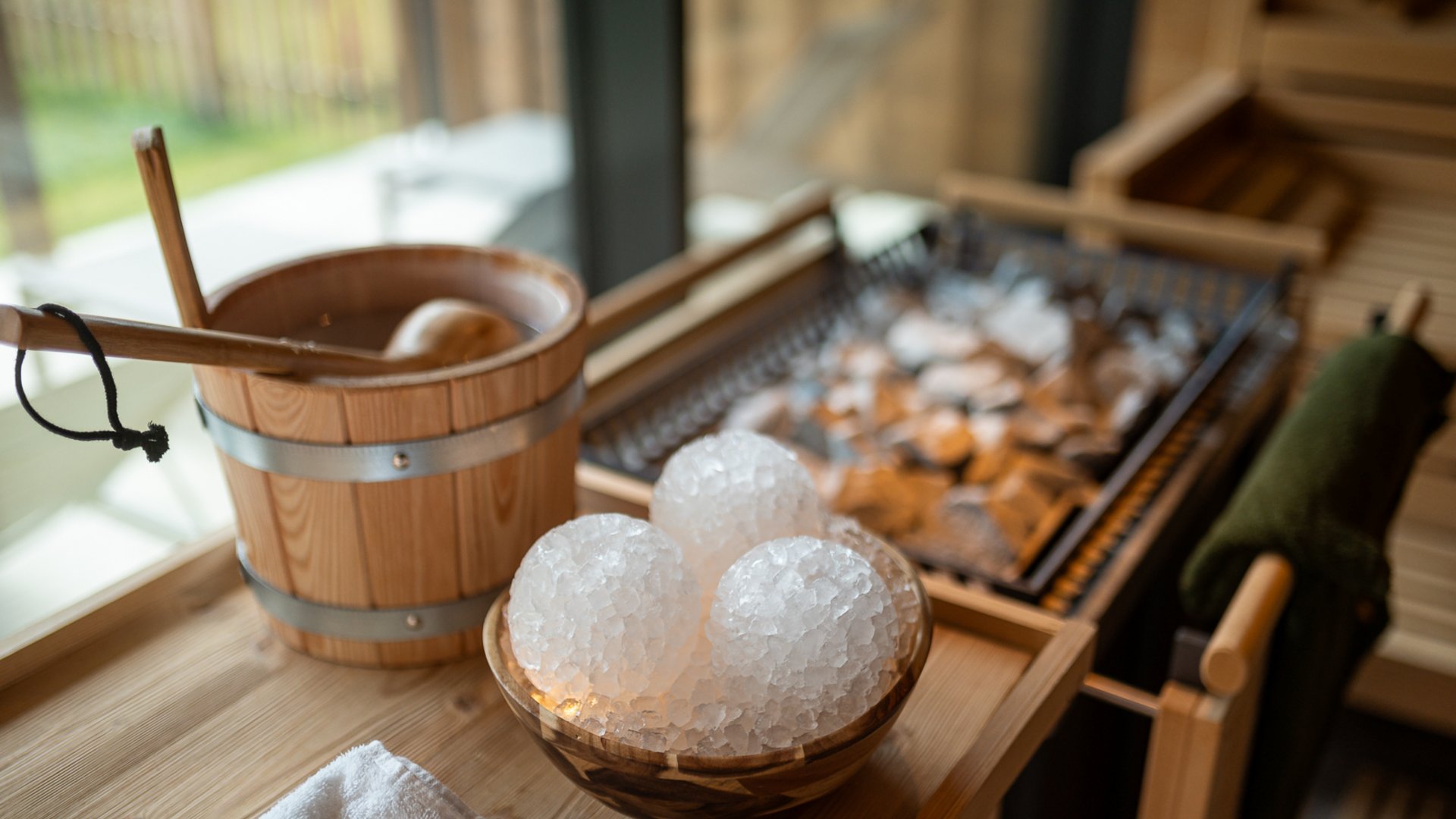 Day Spa inmitten der Kitzbüheler Alpen Sauna mit Holzeimer, Saunakelle und Eis in einer Holzschale