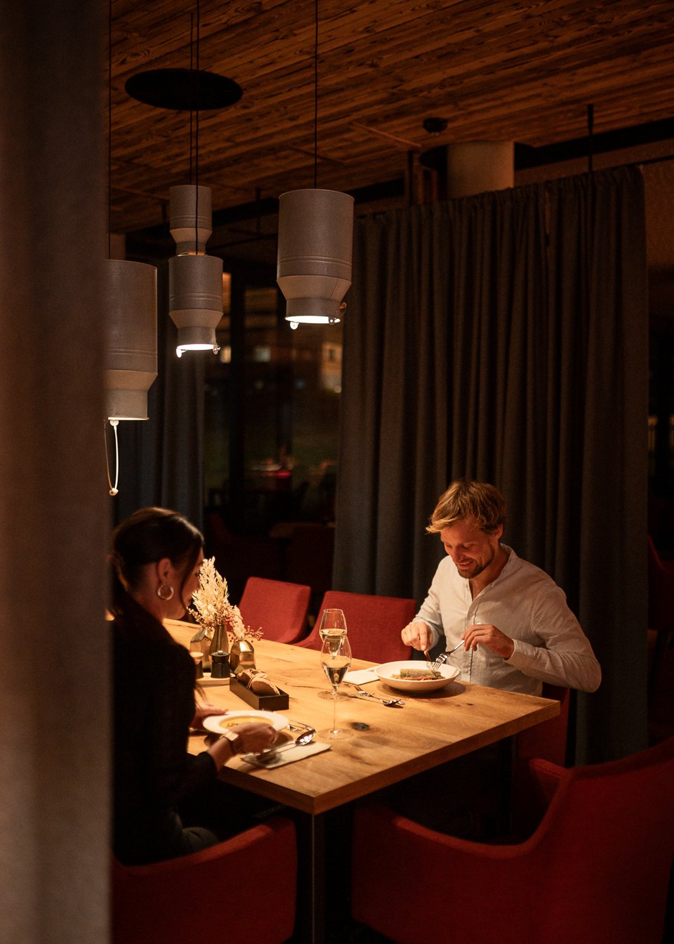 ADEA Lifestyle Suites: Unterkunft in Fieberbrunn Paar beim Abendessen in einem gemütlichen Restaurant mit warmem Licht