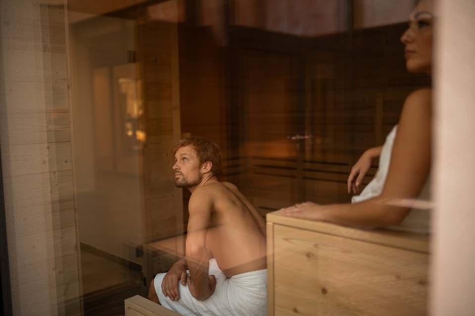 Paar genießt die Sauna mit Bergblick Paar genießt die Sauna mit Bergblick