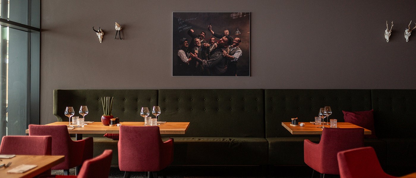 Sitzmöglichkeiten im Restaurant UPSIDEDOWN in Fieberbrunn mit gedeckten Holztischen und roten Stühlen Sitzmöglichkeiten im Restaurant UPSIDEDOWN in Fieberbrunn mit gedeckten Holztischen und roten Stühlen