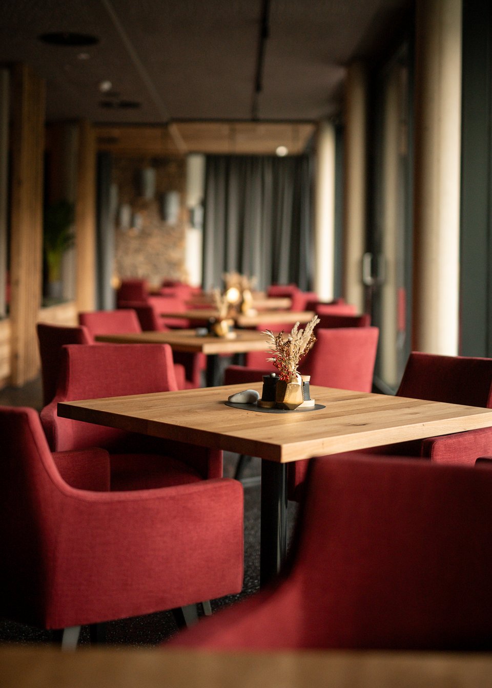 Seating in the UPSIDEDOWN restaurant in Fieberbrunn with red chairs and wooden tables Seating in the UPSIDEDOWN restaurant in Fieberbrunn with red chairs and wooden tables