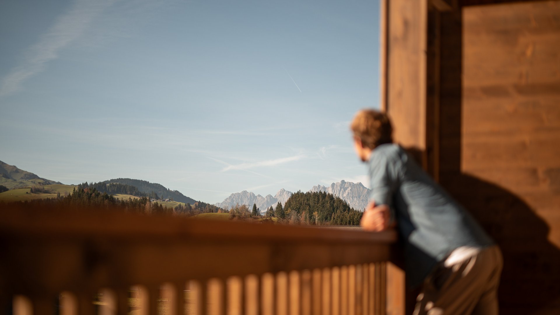 Mann schaut vom Balkon der ADEA Lifestyle Suites auf die Kitzbüheler Alpen Mann schaut vom Balkon der ADEA Lifestyle Suites auf die Kitzbüheler Alpen