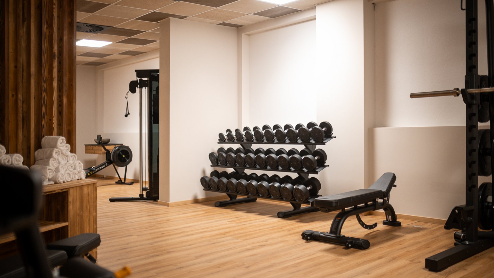 ADEA: dein Hotel mit Fitnessstudio in Österreich Innenansicht eines Fitnessstudios mit Hanteln, Trainingsbank und Rudergerät