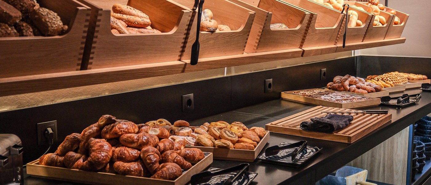 UPSIDEDOWN Restaurant Frisches Brot und Gebäck in Holzregalen und Servierschalen