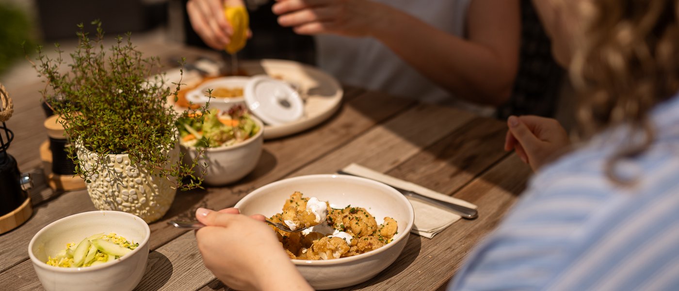 UPSIDEDOWN Restaurant Personen genießen gemeinsam eine Mahlzeit an einem Holztisch
