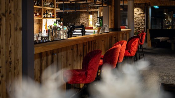 moderne Bar mit roten Sitzhocker im Restaurant UPSIDEDOWN in Fieberbrunn moderne Bar mit roten Sitzhocker im Restaurant UPSIDEDOWN in Fieberbrunn