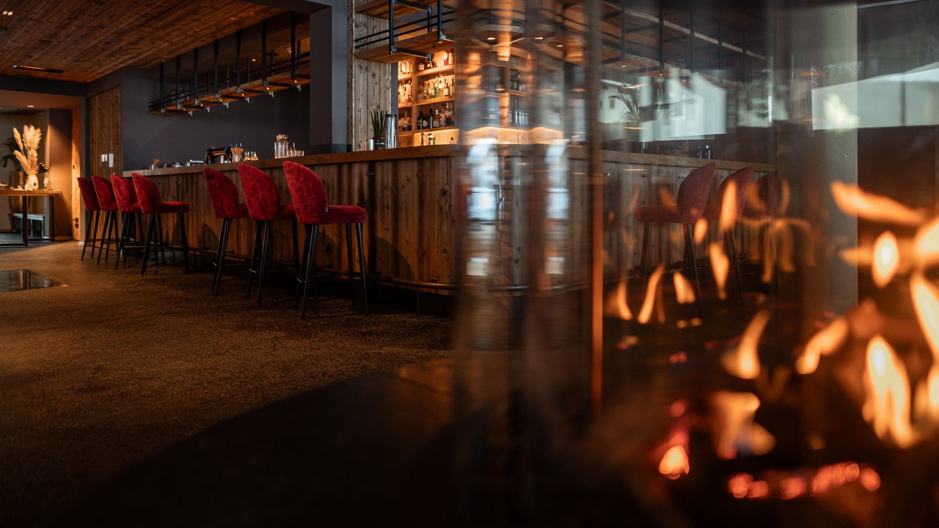 Bar mit Kamin im Vordergrund im Restaurant UPSIDEDOWN in Fieberbrunn Bar mit Kamin im Vordergrund im Restaurant UPSIDEDOWN in Fieberbrunn