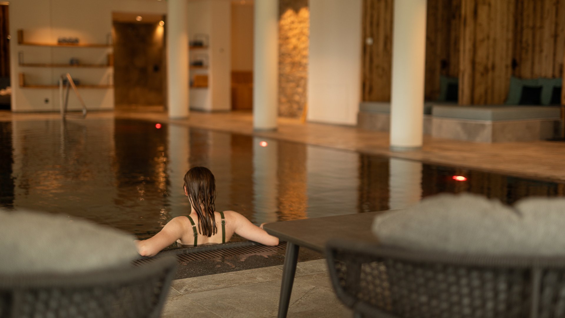 Fieberbrunn: wellness hotel wanted? Woman relaxing in an indoor pool at a modern spa