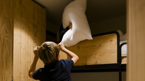 Kinder machen eine Kissenschlacht im Stockbett Kinder machen eine Kissenschlacht im Stockbett
