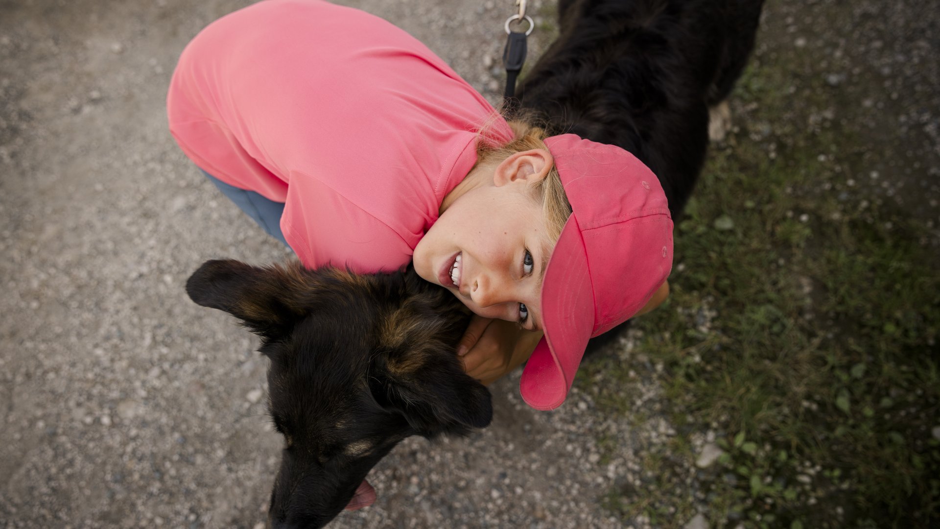 Kind umarmt einen schwarzen Hund Kind umarmt einen schwarzen Hund