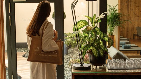 Frau ist im Wellnessbereich an der Getränkestation Frau ist im Wellnessbereich an der Getränkestation