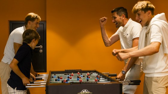 Familie spielt Kicker im Spielezimmer Familie spielt Kicker im Spielezimmer