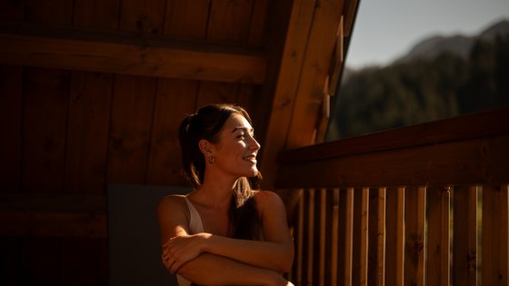 Frau genießt die Aussicht von ihrem Balkon aus Frau genießt die Aussicht von ihrem Balkon aus