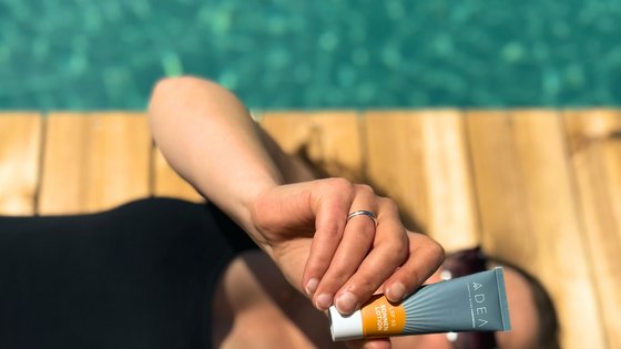 Frau liegt neben Schwimmteich mit ADEA Sonnencreme Frau liegt neben Schwimmteich mit ADEA Sonnencreme