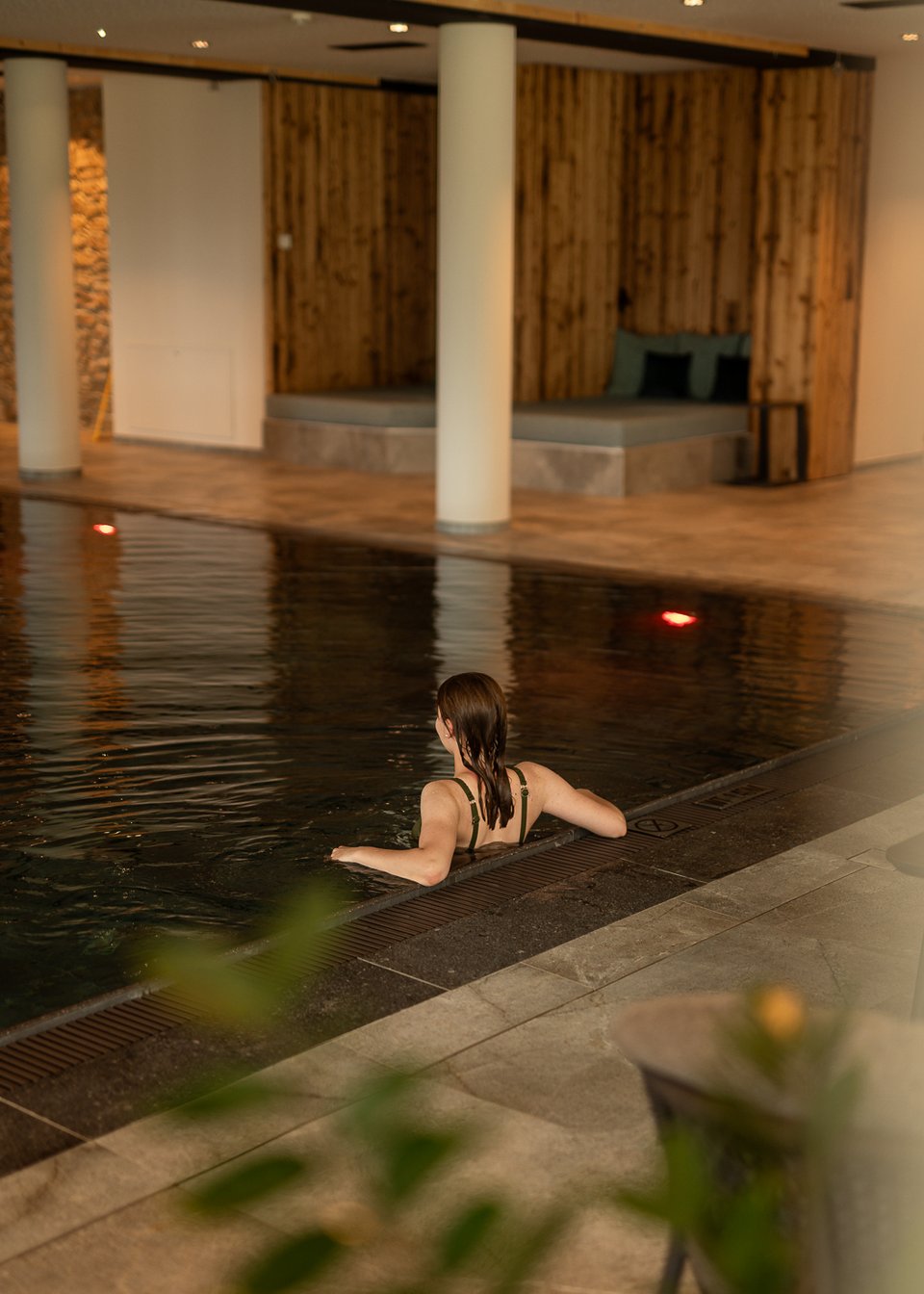 Hotel in Fieberbrunn: ADEA Lifestyle Suites Frau entspannt im Hallenbad an der Beckenrandkante
