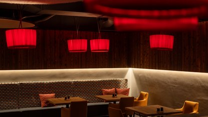 Dark room with red lamps, chairs and tables in the UPSIDEDOWN restaurant in Fieberbrunn Dark room with red lamps, chairs and tables in the UPSIDEDOWN restaurant in Fieberbrunn