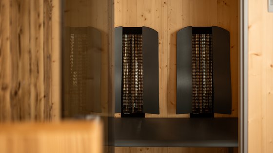 Fieberbrunn: wellness hotel wanted? Black infrared heater mounted on wooden wall in modern room